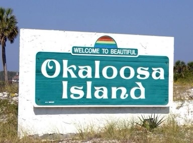 okaloosa island a sign on a pole